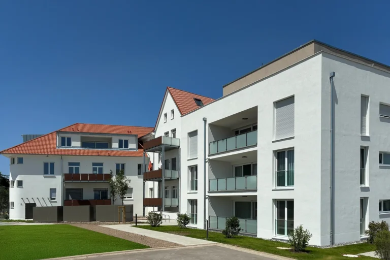 Modernes Mehrfamilienhaus in Rheinau-Freistett mit weißen Fassaden, Balkonen und Grünflächen