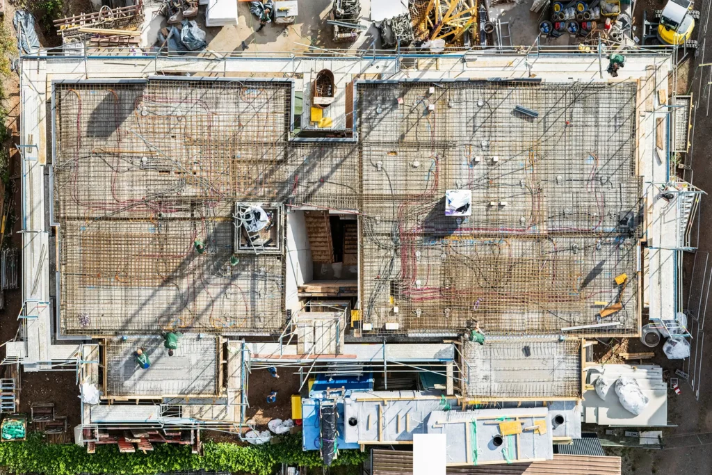 Draufsicht auf die Baustelle in Elgersweier mit sichtbaren Leitungen der Klimadecke – moderne Wohnungen zu kaufen bei Orbau.