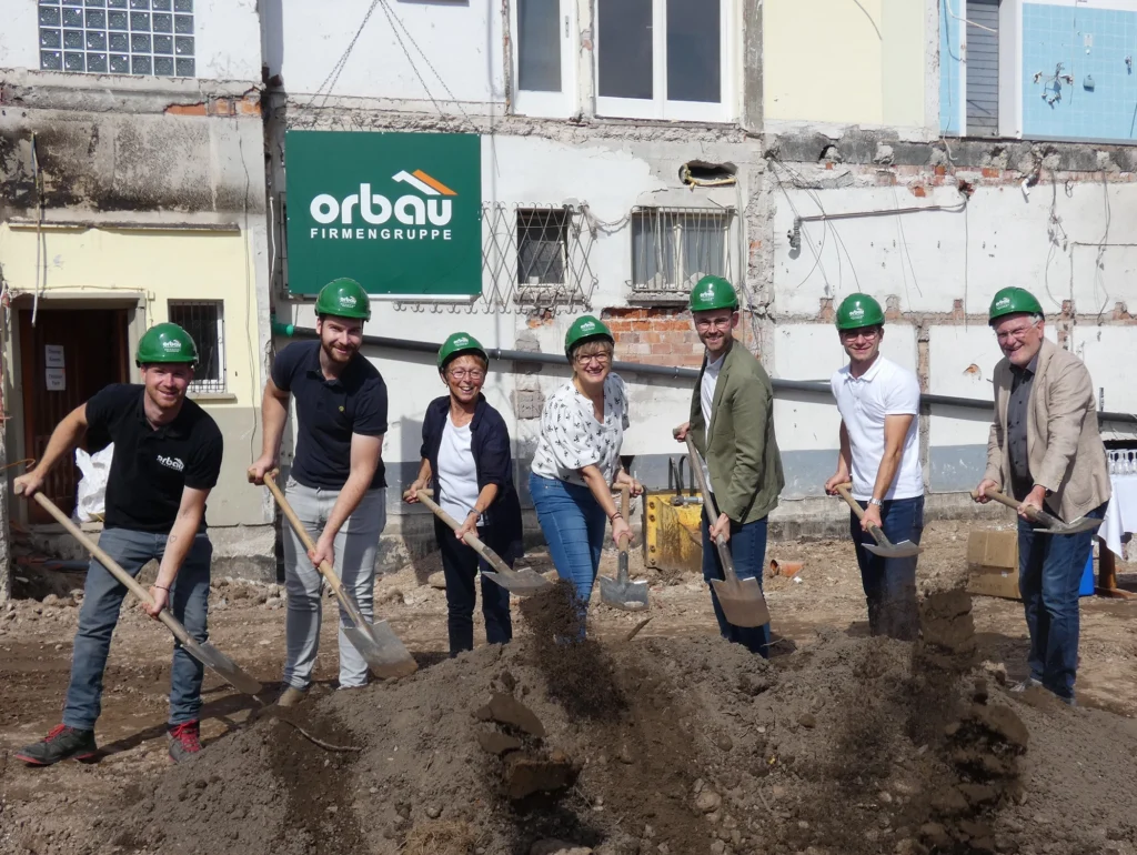 Team mit grünen Helmen beim Spatenstich in Biberach