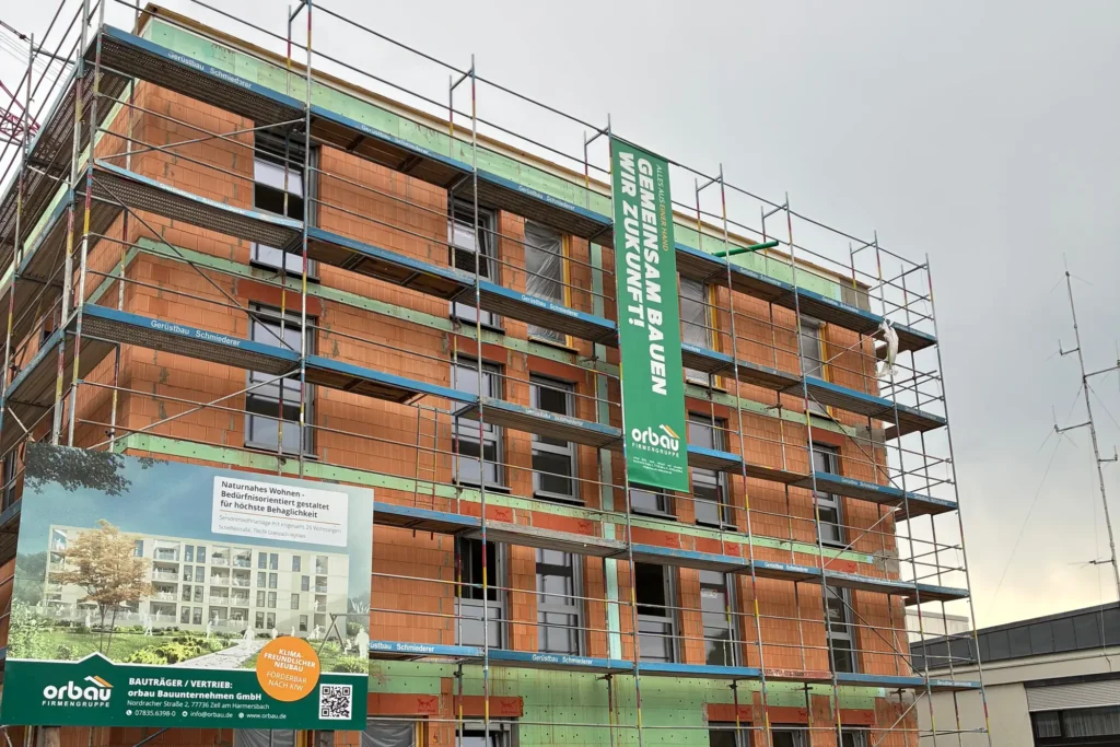 Bauprojekttafel der orbau Firmengruppe für zwei moderne Mehrfamilienhäuser in Offenburg-Elgersweier. Nur noch 4 Wohnungen zu kaufen – hochwertige Immobilien zu verkaufen mit 3–4 Zimmern, 76–125 m², Fertigstellung Ende 2025.