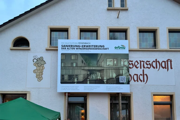 Das Bauschild vom Bauvorhaben vor dem Gebäude der Winzergenossenschaft.
