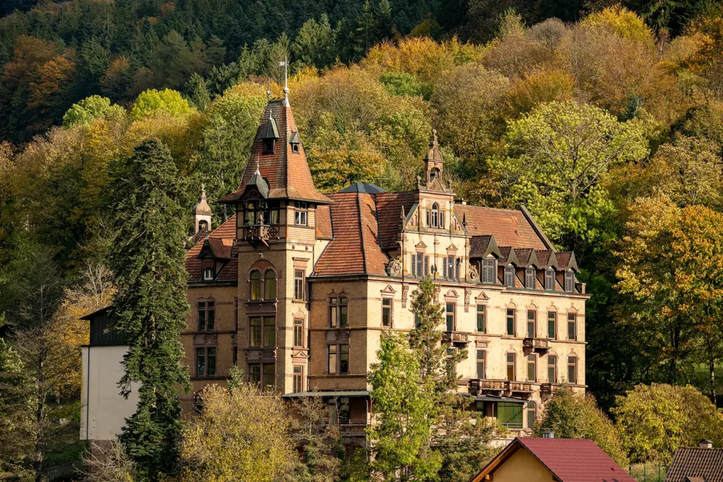 Historisches Schloss Rothschild in Nordrach, umgeben von herbstlichem Wald – Sanierungsprojekt der orbau Firmengruppe.