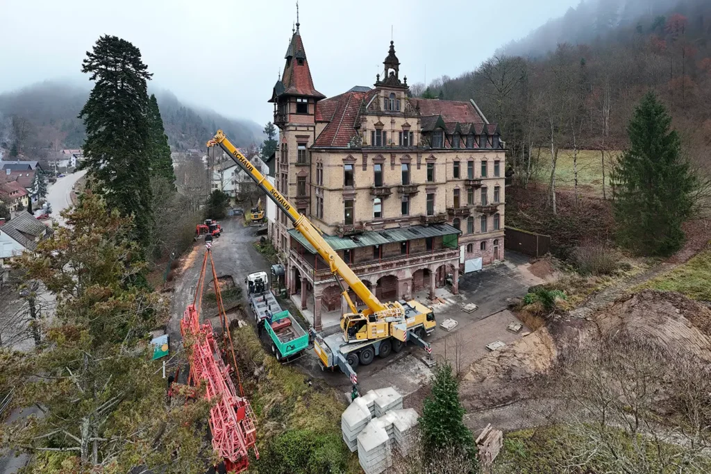 Luftaufnahme zeigt Kranaufbau, Baustellengelände und Schloss Rothschild im Hintergrund