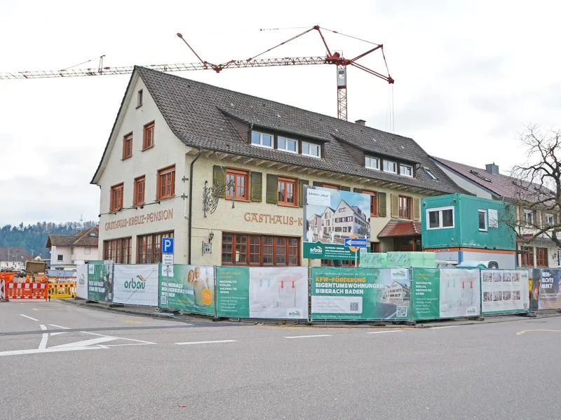 Das Gebäude des ehemaligen Gasthaus Kreuz in Biberach mit Bauzäunen umringt und Baukran im Hintergrund.
