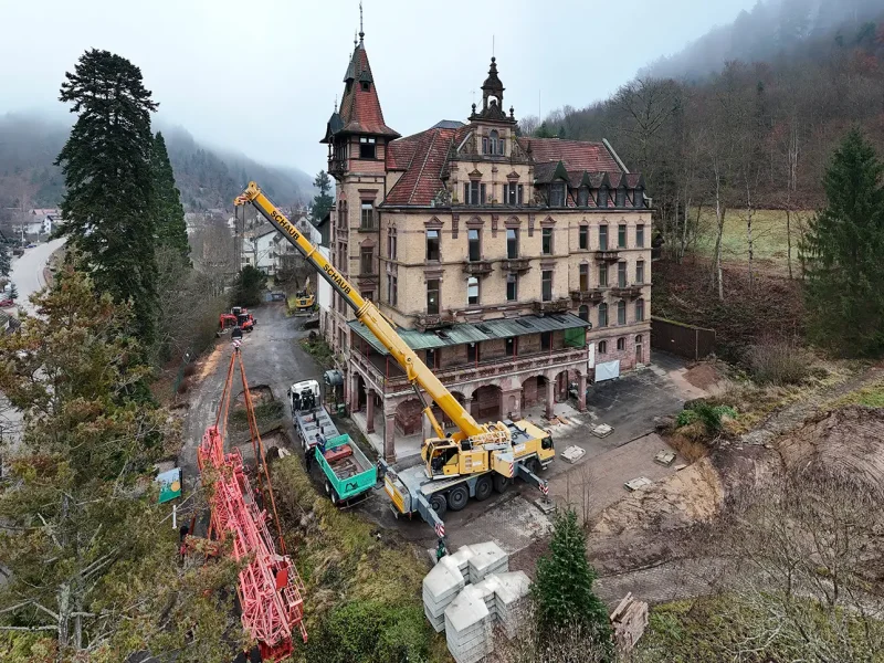 Luftaufnahme zeigt Kranaufbau, Baustellengelände und Schloss Rothschild im Hintergrund