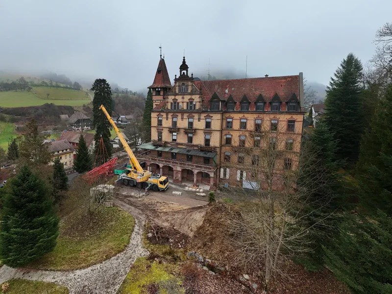 Weitwinkelaufnahme des Schlosses Rothschild mit aufgestelltem Baukran und umliegender Landschaft