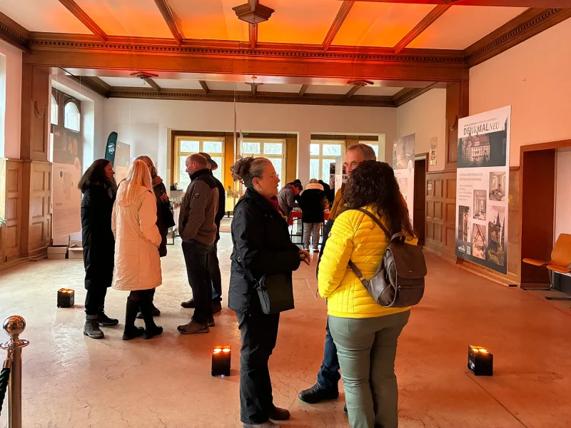 Besucher im Innenraum des Schlosses Rothschild im Gespräch während des Weihnachtsmarktes