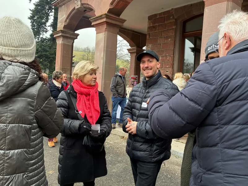 Besucher im Gespräch vor dem Schloss Rothschild während des Weihnachtsmarktes