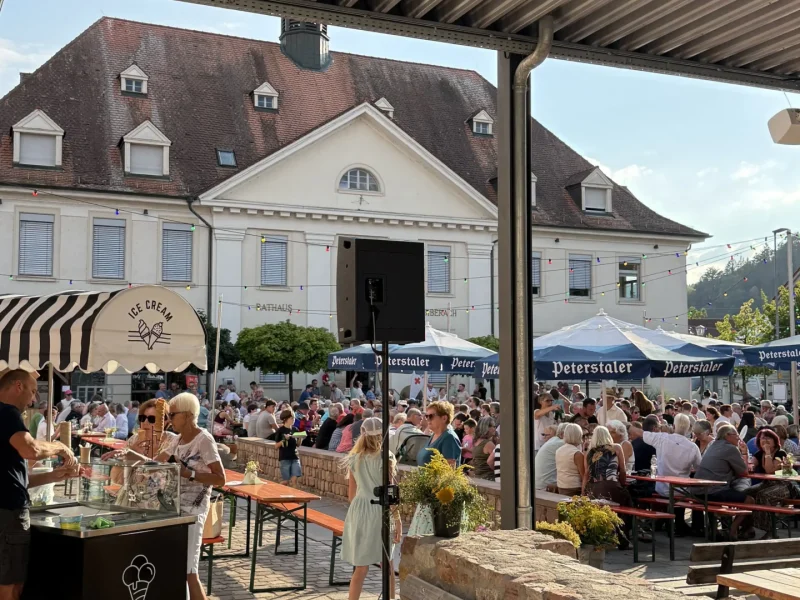 Gut besuchter Tavernenabend auf dem Rathausplatz in Biberach mit zahlreichen Gästen bei sommerlicher Atmosphäre.