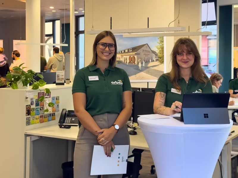 Zwei Mitarbeiterinnen der orbau Firmengruppe begrüßen Gäste beim Pre-Sale Event in Offenburg