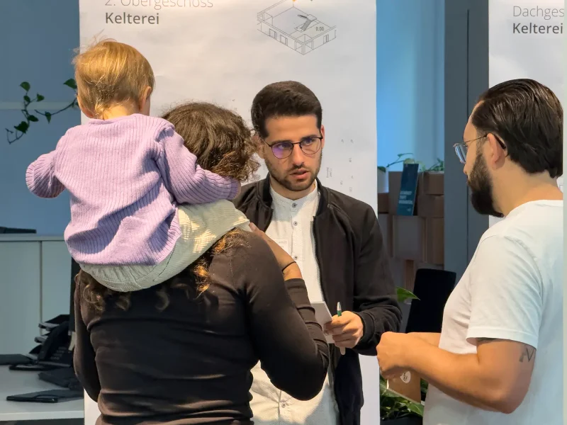 Mitarbeiter im Gespräch mit jungen Eltern beim Pre-Sale Event der orbau Firmengruppe