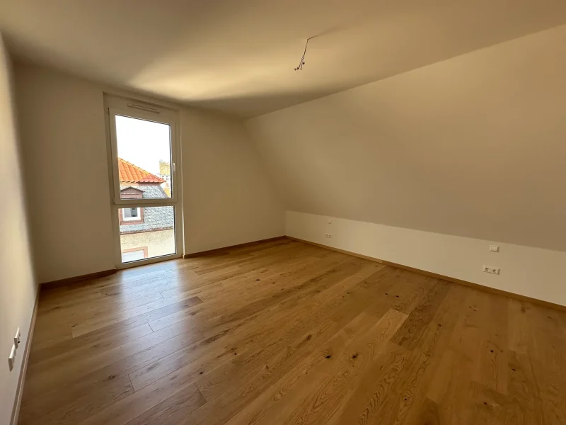 Geräumiges Schlafzimmer mit viel Tageslicht und Zugang zur Ankleide in einer Wohnung in Baden-Baden