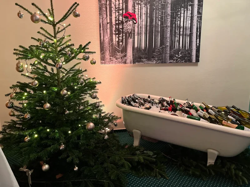 Badewanne mit Getränken und festlich geschmückter Weihnachtsbaum auf der Weihnachtsfeier 2022 im Schwarzwaldhotel in Gengenbach