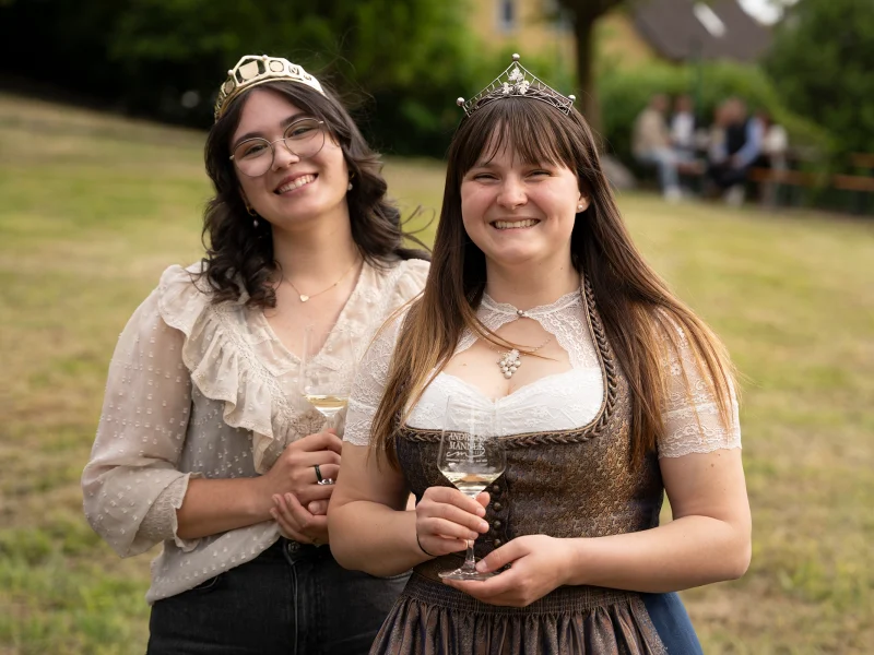 Zwei junge Frauen mit Krone und Weinglas