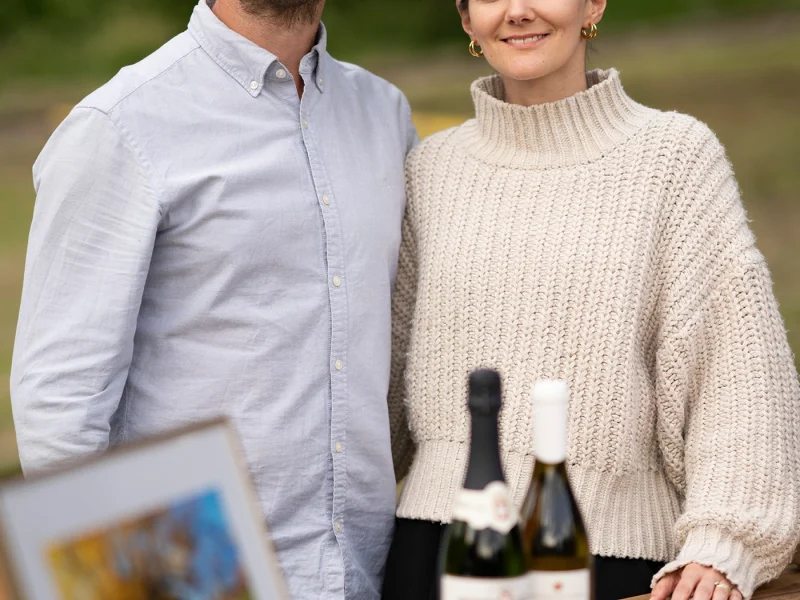 Mann und Frau am Weintisch mit Kunst und Flaschen