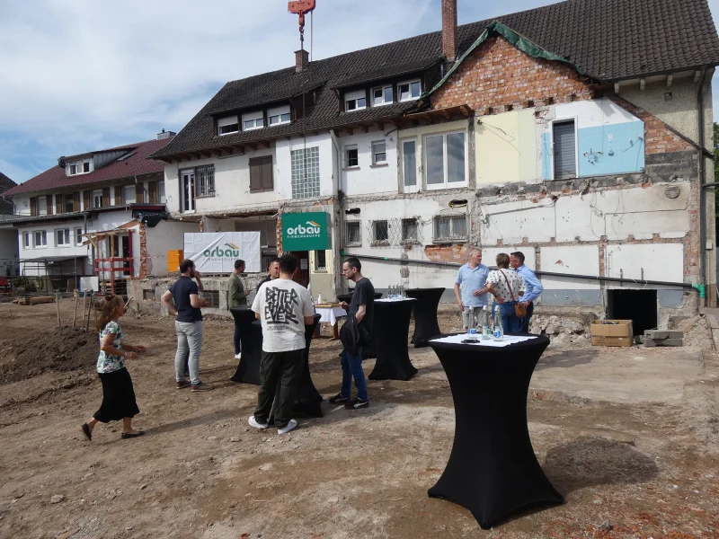 Besucher beim Spatenstich vor dem Altbau in Biberach